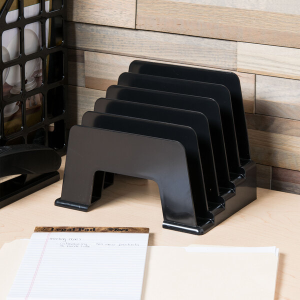 A black Universal plastic incline sorter holding paper on a wood desk.