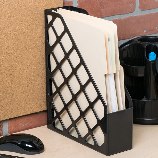 A black Universal magazine file holder on a desk with papers in it.