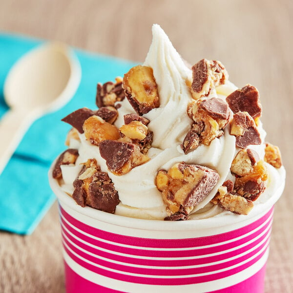 A cup of ice cream topped with a chopped SNICKERS® bar.
