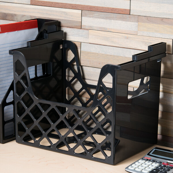A black plastic desktop file holder with papers and a calculator inside.