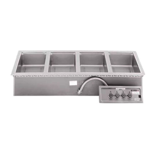 A Wells 4 pan drop-in hot food well with infinite control knobs in a stainless steel counter.