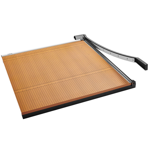 A X-Acto paper cutter with a metal handle and a grid on a wood base.