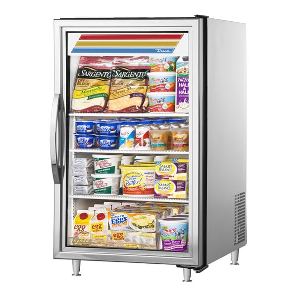 A True stainless steel countertop glass door refrigerator full of dairy products with the door open.