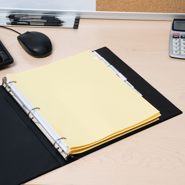A file folder with yellow paper in an Avery clear tab divider on a desk.