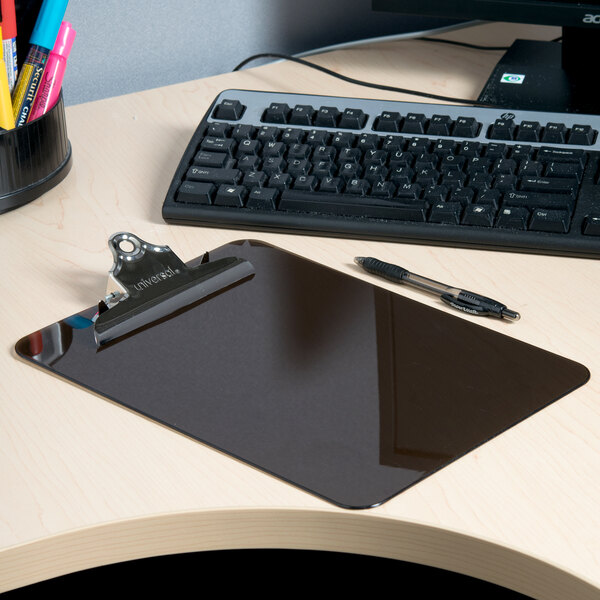 A Universal smoke plastic clipboard on a desk with a black pen.