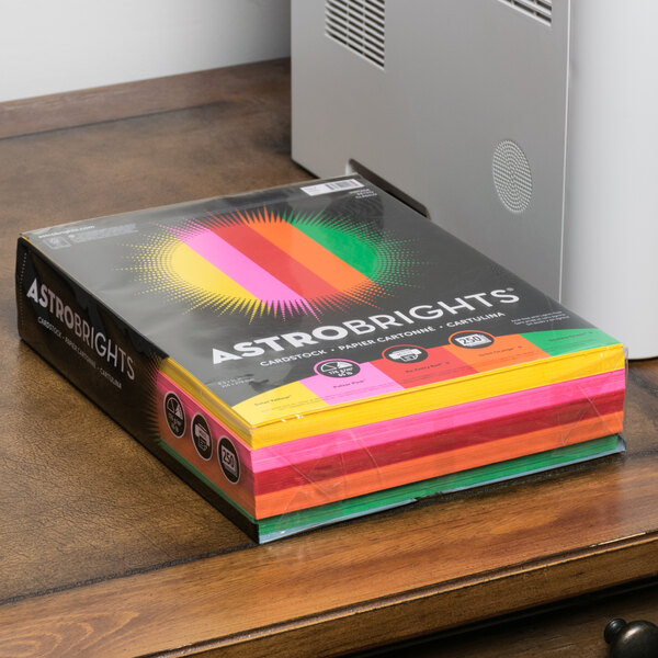 A box of Astrobright colorful paper on a table.