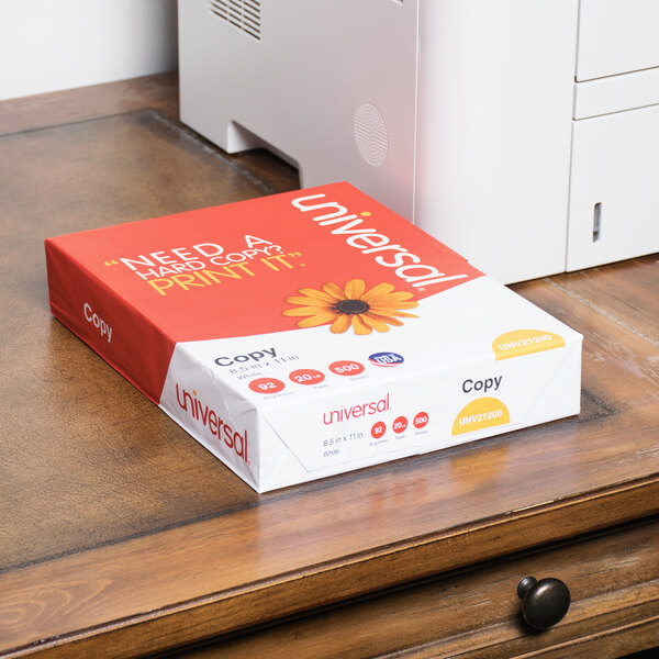 A red and white Universal Office copy paper box on a desk.