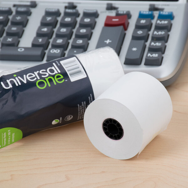 A roll of Universal Office white thermal paper next to a calculator.