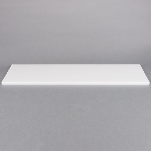 A white rectangular object on a gray surface.
