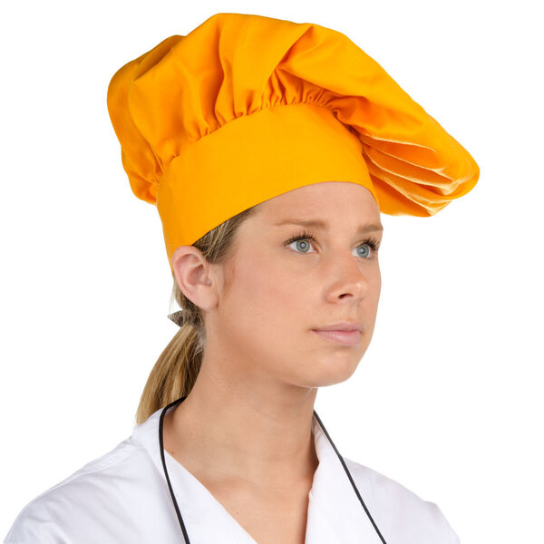 A woman wearing a gold Intedge chef's hat.