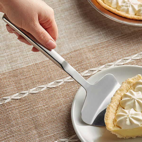 A hand using a Vollrath stainless steel pie server to slice a pie.
