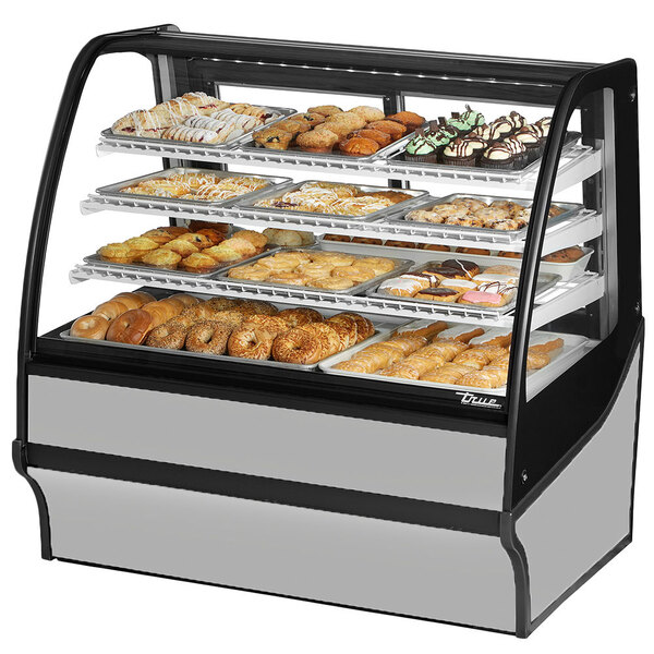 A True curved glass stainless steel dry bakery display case full of pastries.