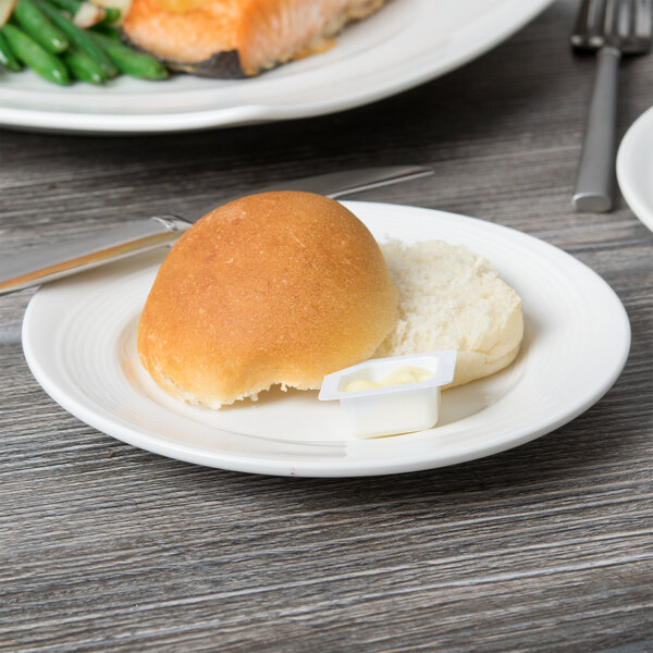 A Reserve by Libbey white porcelain plate with food including a bread roll and sandwich.