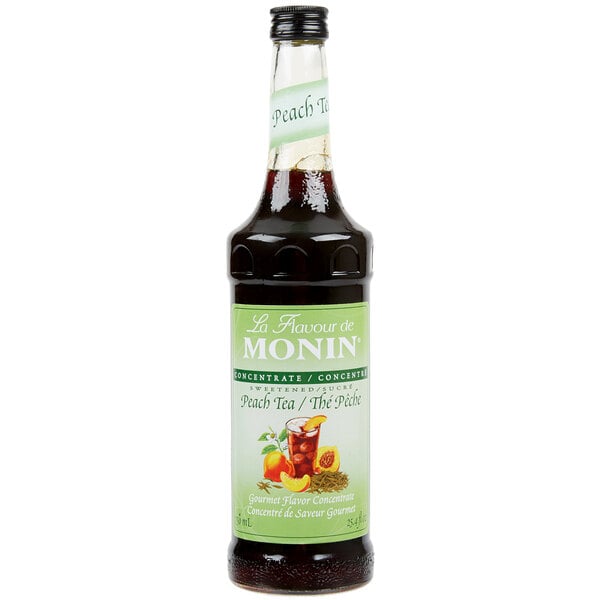A Monin 750 mL bottle of Peach Tea concentrate with a label.