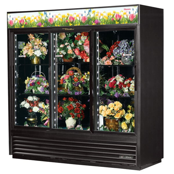 A True refrigerated floral case with a display of flowers.