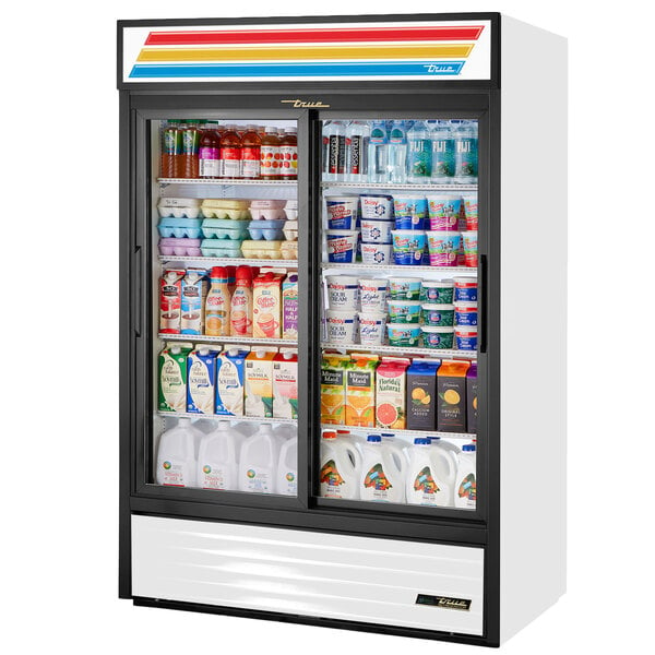A white True refrigerated glass door merchandiser filled with drinks and beverages.