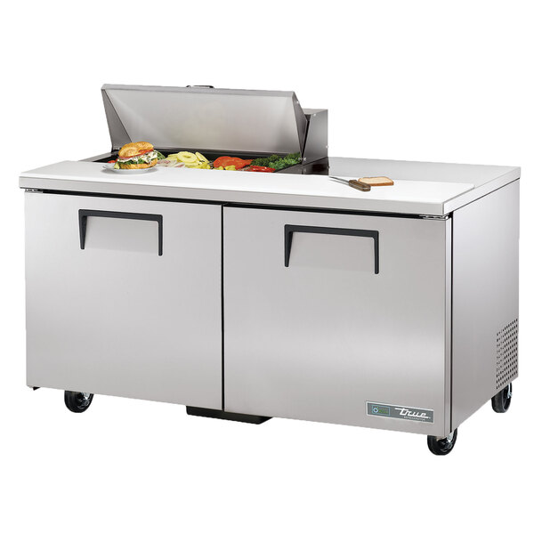 A True stainless steel refrigerator with food on top.