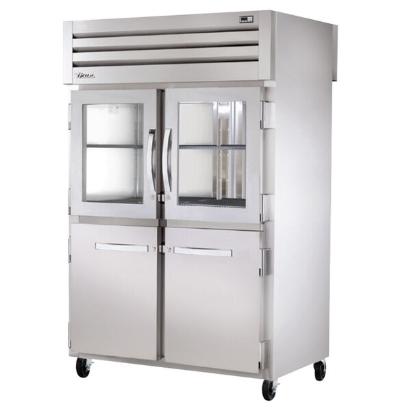 A large stainless steel True pass-through refrigerator with half glass front doors and solid back doors.