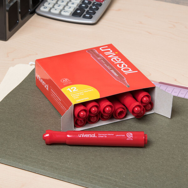 A box of Universal red chisel tip permanent markers on a desk.
