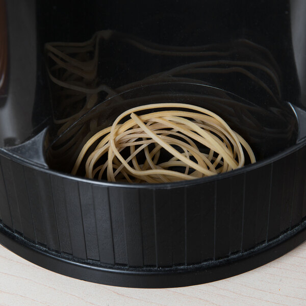 A black container with a black lid with a bunch of beige rubber bands inside.