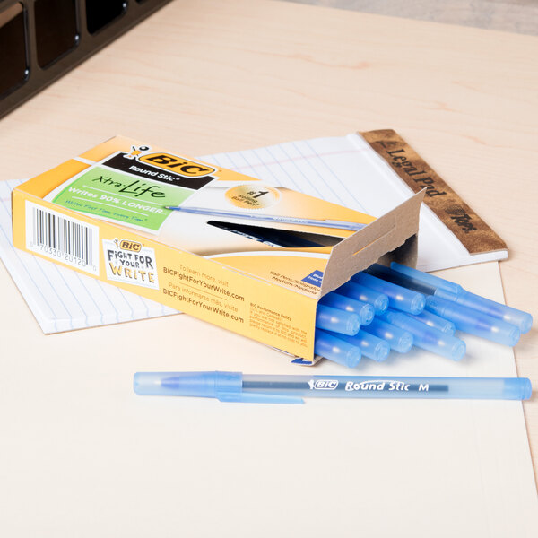 A yellow box of Bic blue pens on a white surface.
