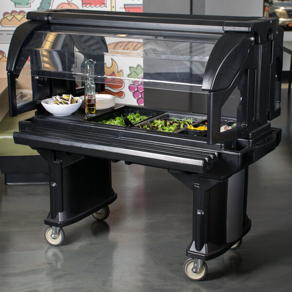 A black Cambro Versa Salad Bar on a food buffet with a tray of salads.