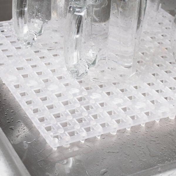 A Choice clear interlocking bar mat on a counter with clear mugs on it.