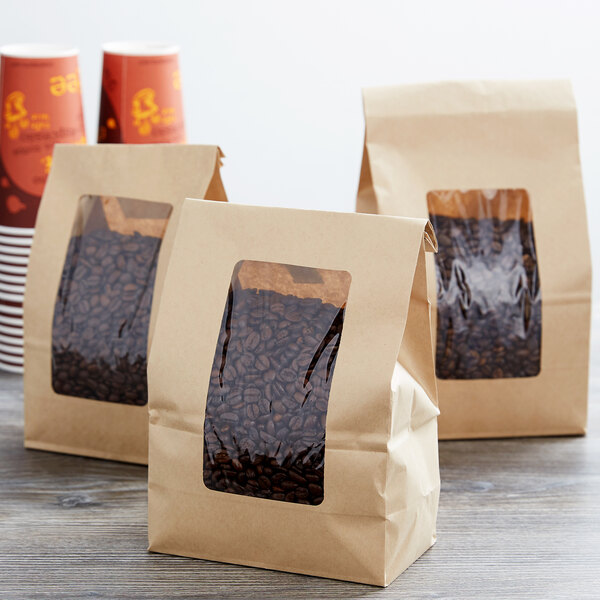 Three brown Choice brown Kraft paper bags with coffee beans inside.