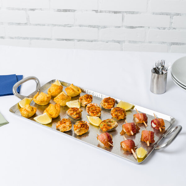 A American Metalcraft small rectangular stainless steel griddle tray of food on a table.