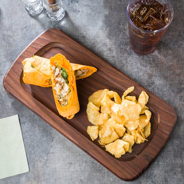 An American Metalcraft ash wood serving board with a burrito and chips on a table.