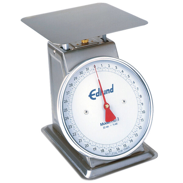 An Edlund heavy duty portion scale with a white top and red dial on a counter.