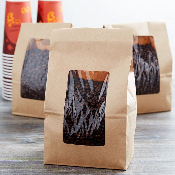 A group of brown Choice paper bags with coffee beans in them.