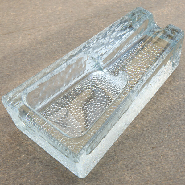 A Libbey glass cigar ashtray on a wood surface.