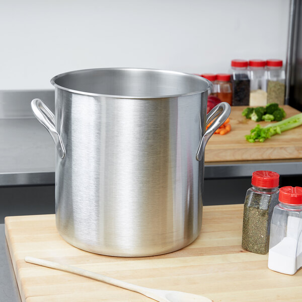 A large silver Vollrath stainless steel stock pot on a wood surface.