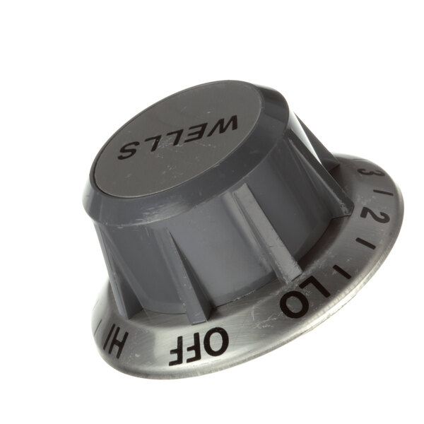 A grey metal Wells T-Stat knob with black text reading "mett" on it.