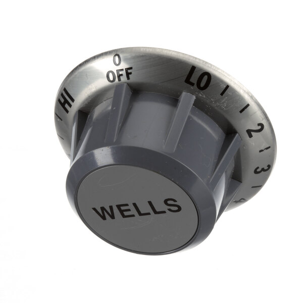 A grey plastic Wells knob with black text.