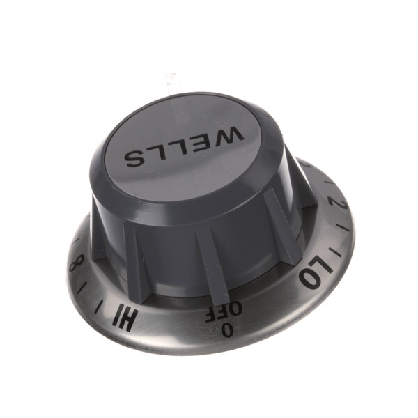 A grey Wells thermostat knob with black text.