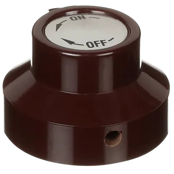 A brown plastic switch with a white circle and a hole in the center.