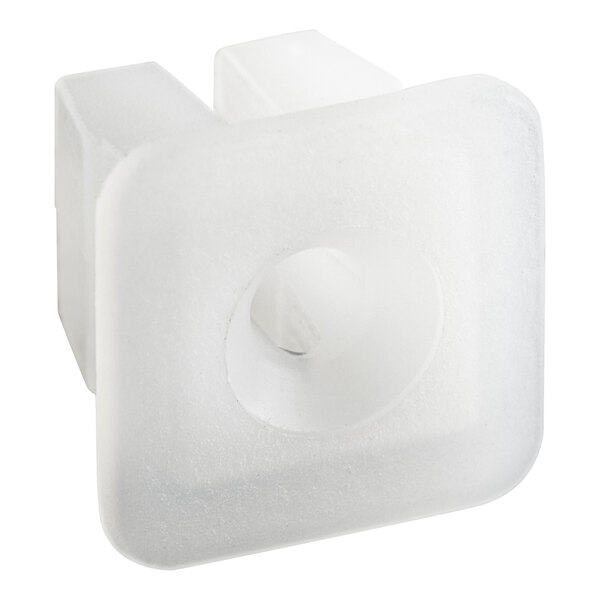A white square plastic piece with a hole in it.