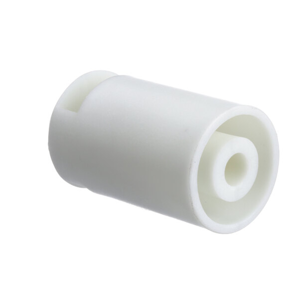 A close-up of a white plastic bushing with a hole.