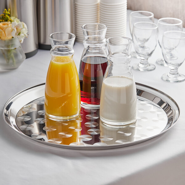 A Thunder Group stainless steel tray with glasses and bottles of various drinks on it.