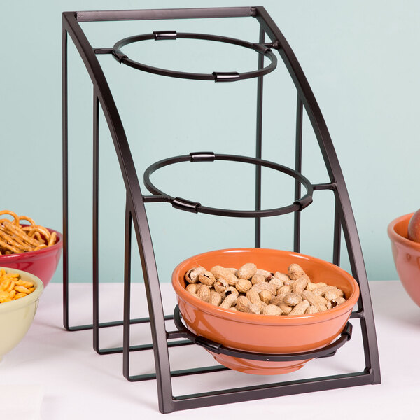 A bowl of peanuts on a black metal display stand with bowls.