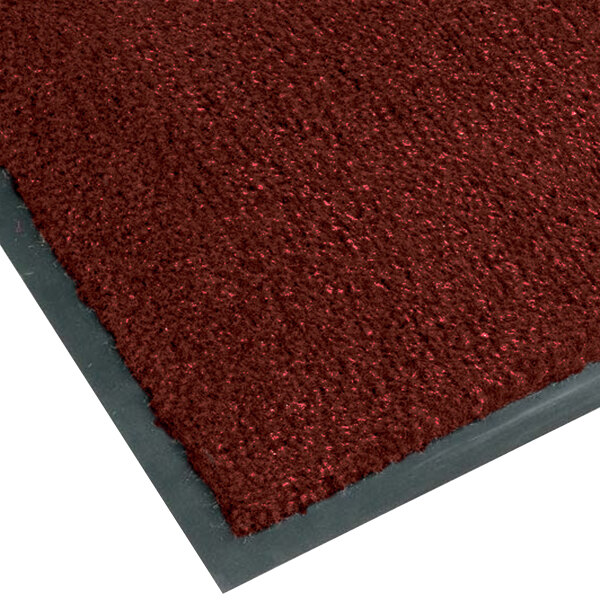 A crimson carpet entrance mat with a grey border.