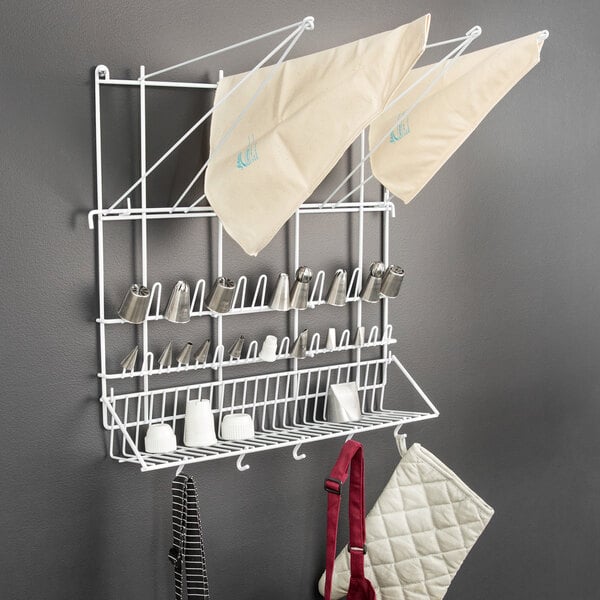 A white plasticized wire rack with white and red pastry bags on it.