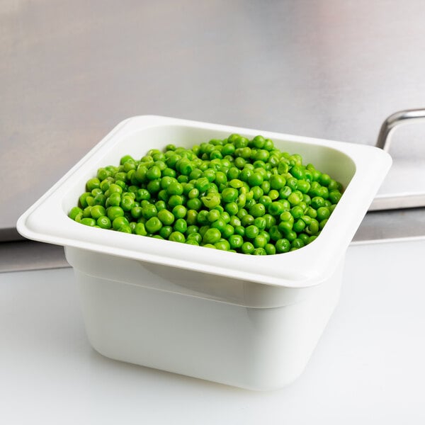 A Cambro white polycarbonate food pan filled with green peas.