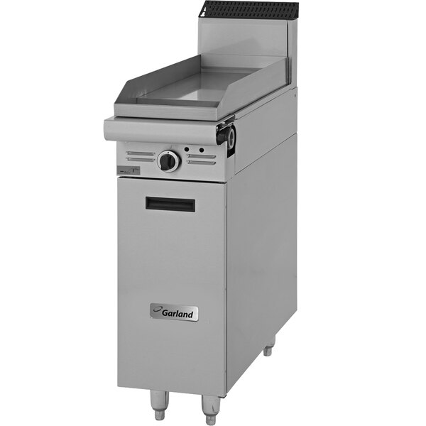 A Garland commercial gas griddle with storage base and manual controls.