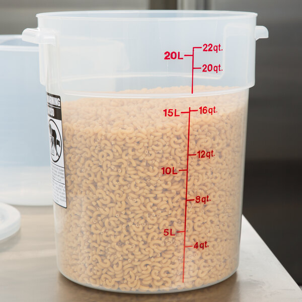 A translucent plastic Cambro food storage container on a counter filled with noodles.