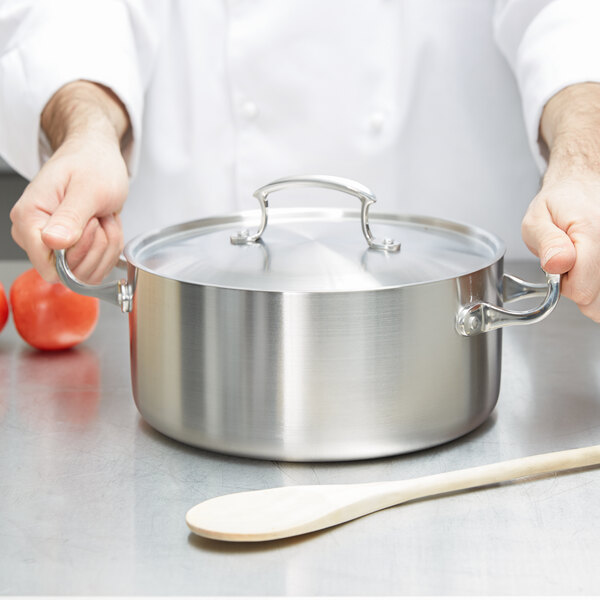 A chef holding a Vollrath Miramar casserole pan with a low dome cover.