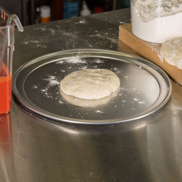 A round dough on an American Metalcraft aluminum pizza pan.