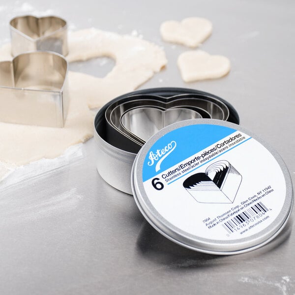A metal heart shaped cookie cutter from the Ateco 6-Piece Stainless Steel Plain Heart Cutter Set used on dough.
